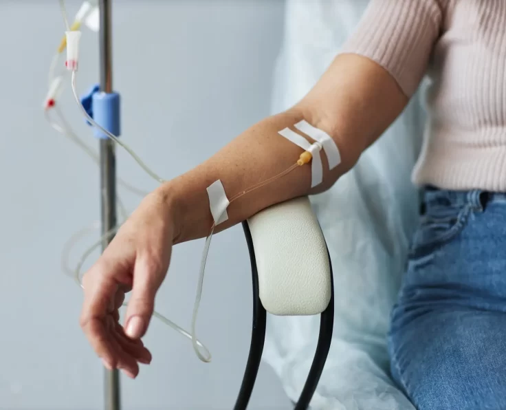 Female hand with IV drip infusion in treatment session