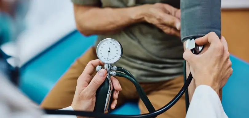 Close up of doctor measuring blood pressure of an elderly patient.