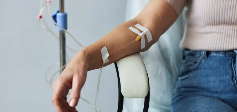 Female hand with IV drip infusion in treatment session