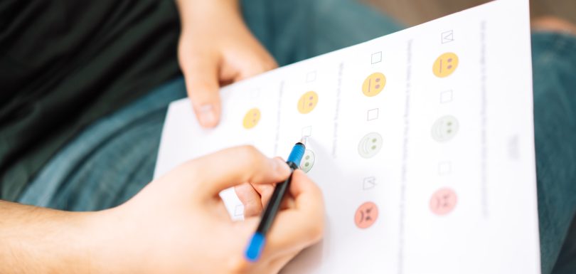 Man taking a psychological test with emoticons