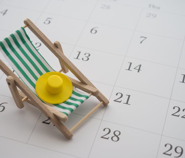 Green beach chair and hat on white blank calendar background copy space. Annual leave travel period for relaxation concept. Period of paid time off (PTO) granted to employees by their employer.
