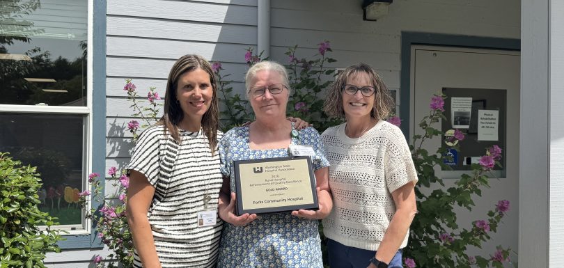 Kelly Thompson, Chief of Nursing, Deborah Dillon, Director of Patient Safety & Quality and Heidi Anderson, CEO pose with the 2026 Rural Hospital Achievement of Quality Excellence Gold Award from the Washington State Hospital Association in front of Forks Hospital
