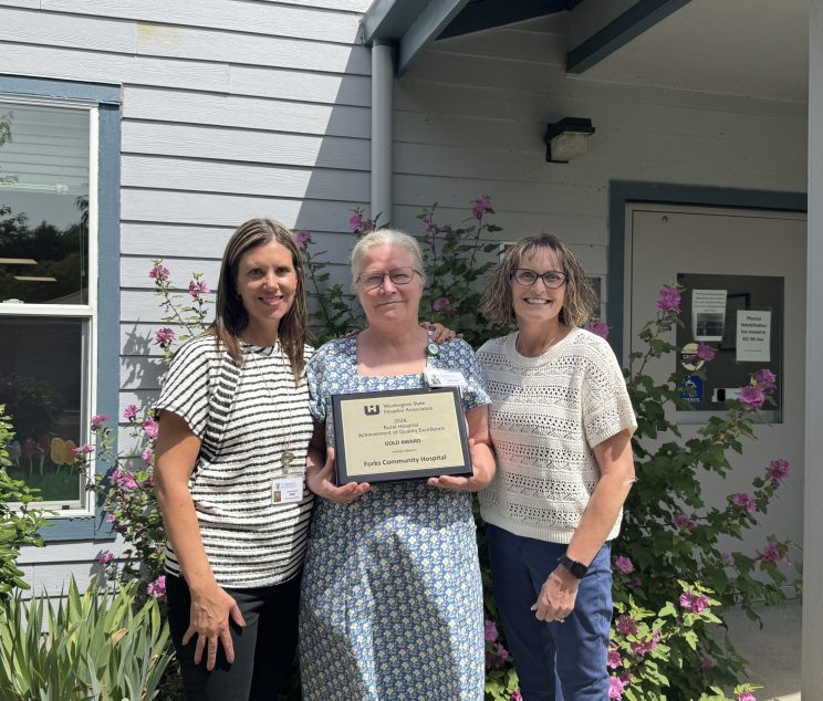 Kelly Thompson, Chief of Nursing, Deborah Dillon, Director of Patient Safety & Quality and Heidi Anderson, CEO pose with the 2026 Rural Hospital Achievement of Quality Excellence Gold Award from the Washington State Hospital Association in front of Forks Hospital