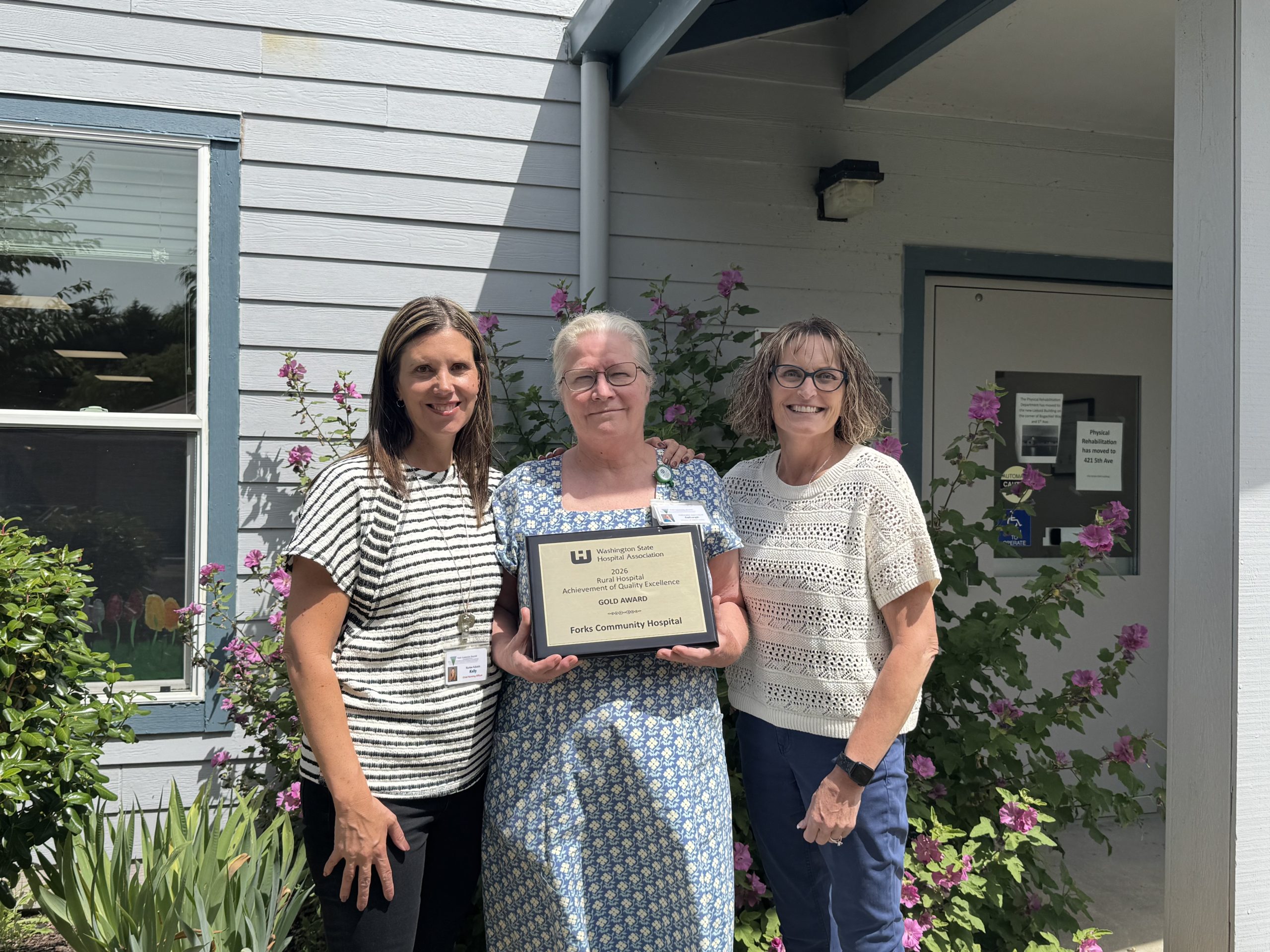 Kelly Thompson, Chief of Nursing, Deborah Dillon, Director of Patient Safety & Quality and Heidi Anderson, CEO pose with the 2026 Rural Hospital Achievement of Quality Excellence Gold Award from the Washington State Hospital Association in front of Forks Hospital